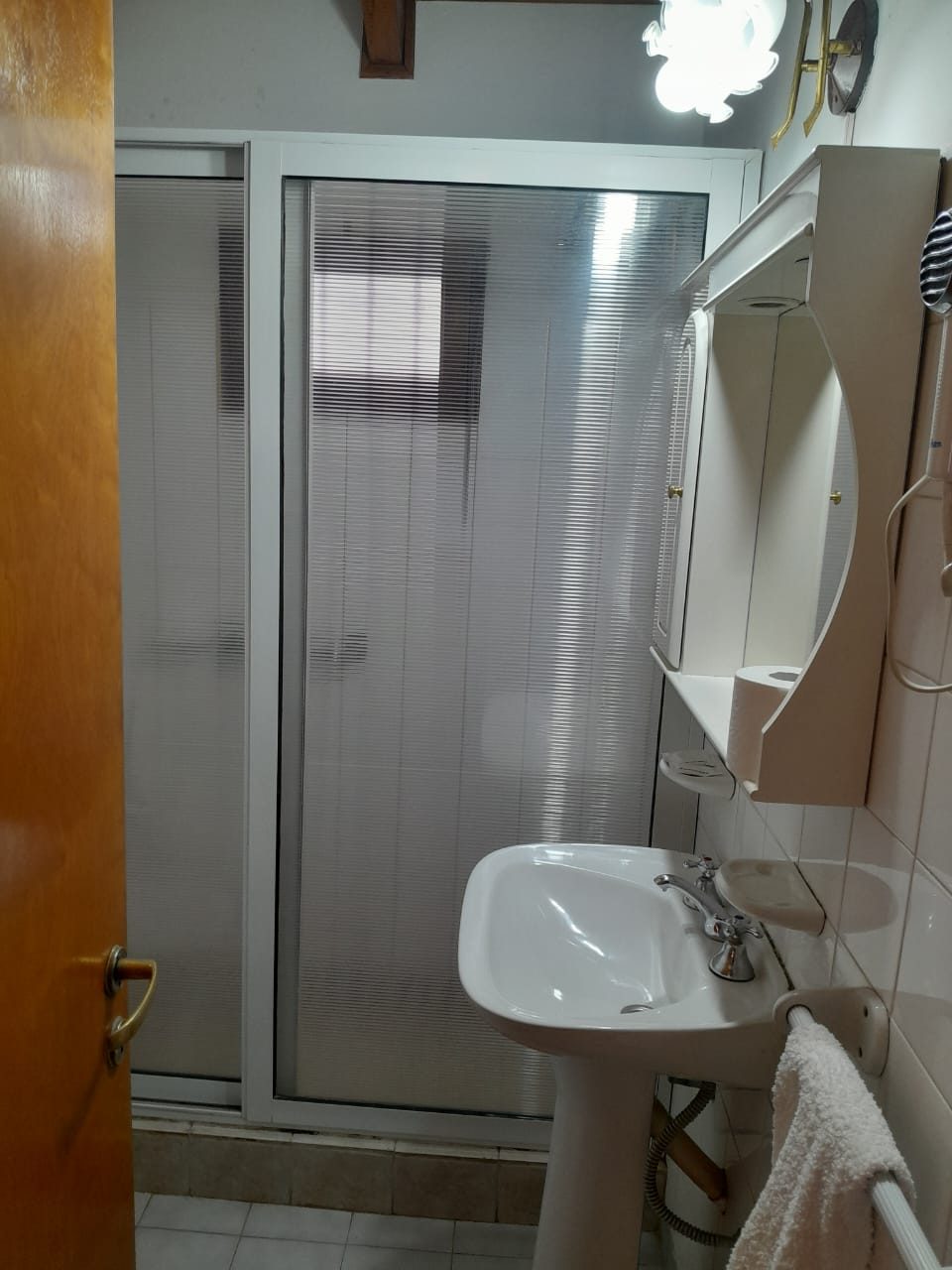 Baño completo con ducha, lavatorio y espejo, impecable