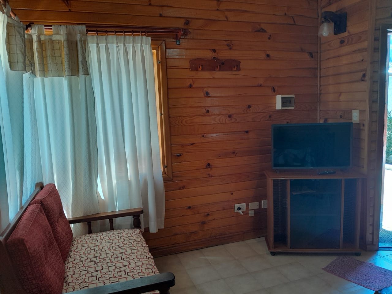 Rincón del living con el sillón, el calefactor y la puerta que da al parque